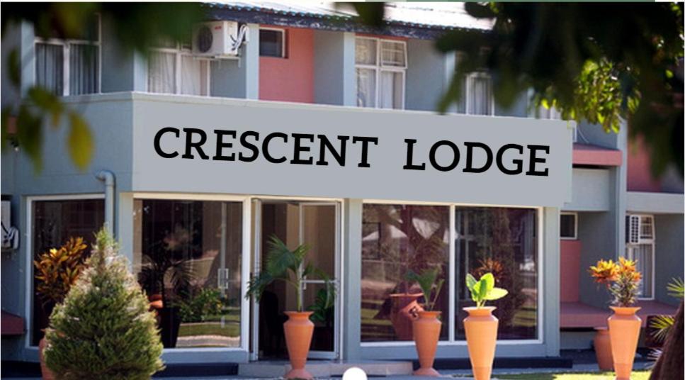 een winkel met een bord dat de huidige lodge leest bij Crescent Lodge in Livingstone