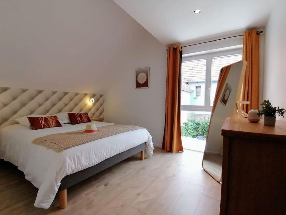 een slaapkamer met een bed en een groot raam bij Du côté de chez Pam in Beblenheim