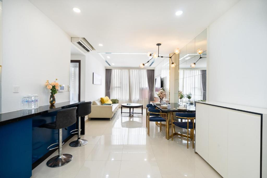 Il comprend une cuisine et un salon avec une table et des chaises. dans l'établissement TRESOR POOL GYM, LE COEUR CHALEUR DE SAIGON, à Hô-Chi-Minh-Ville