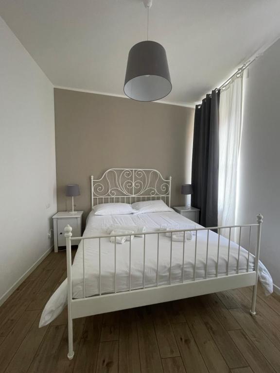 - un lit blanc dans une chambre blanche avec une lampe dans l'établissement Galleria Beta, à Trieste