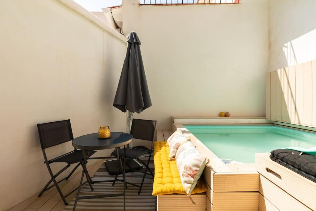 a small pool with a table and chairs and an umbrella at cozy loft patio+pool +wifi in Valencia