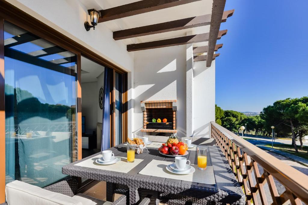 a table with a bowl of fruit on a balcony with a fireplace at Falesia Beach A in Albufeira