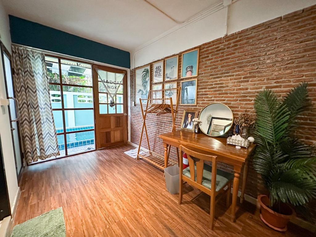 a room with a desk with a mirror and a brick wall at T-House BKK 2Floors near BTS with swimming pool and free Wifi in Klong Toi