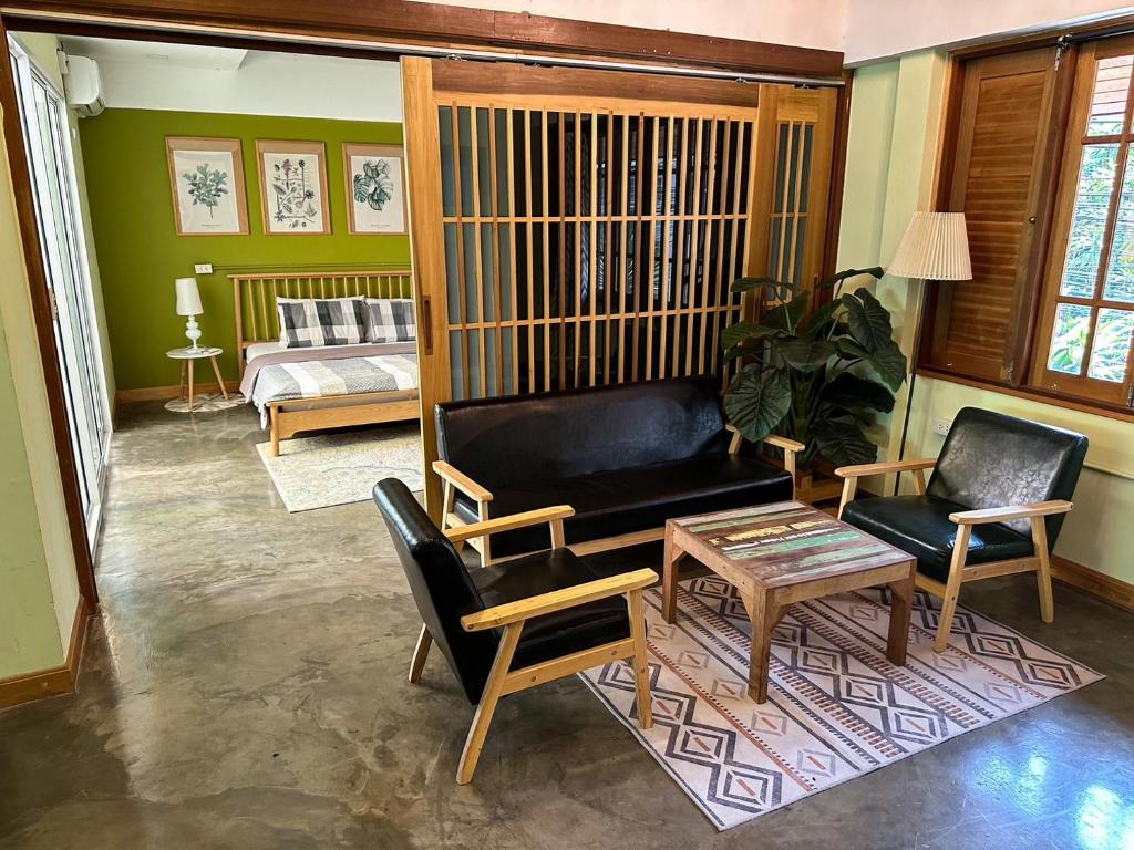 a living room with a couch and a table and chairs at T-House BKK 2Floors near BTS with swimming pool and free Wifi in Klong Toi