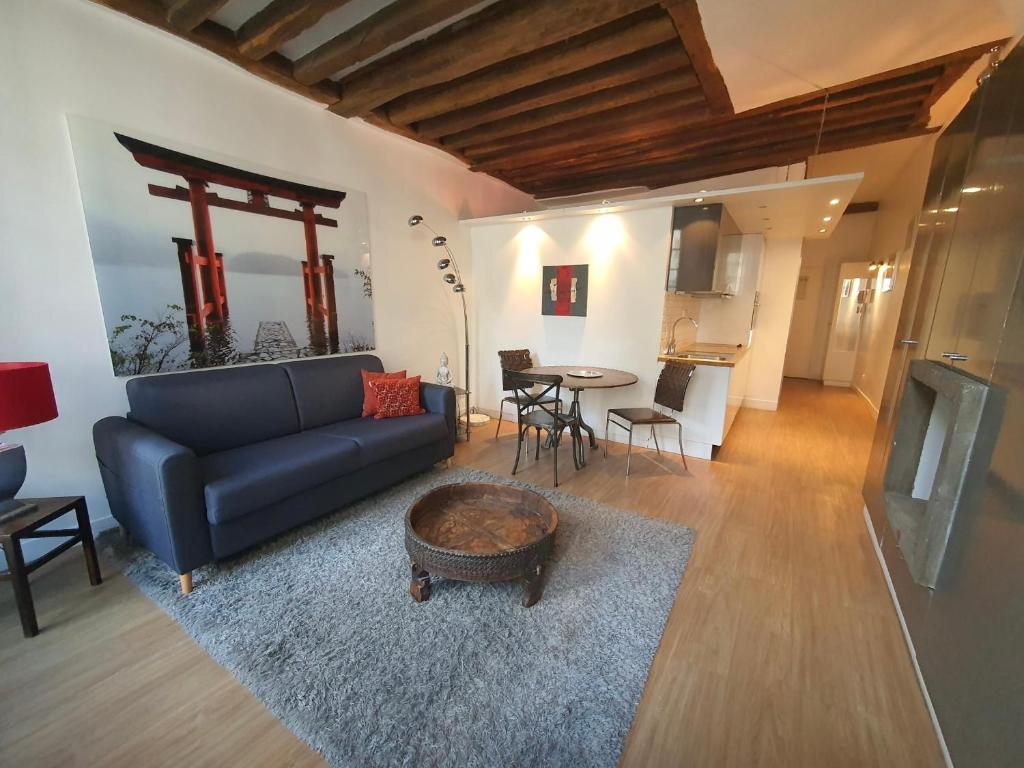 a living room with a blue couch and a table at Couleur St Martin in Paris