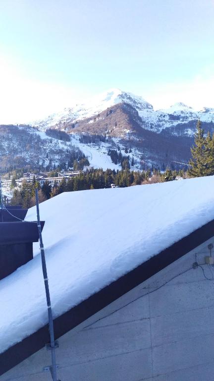 a snow covered roof with a view of a mountain at CASA DESIRE' in Piancavallo