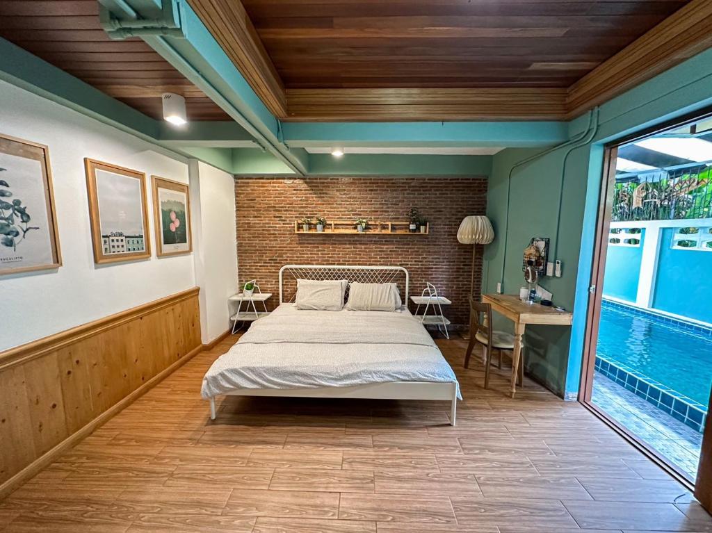 a bedroom with a bed and a table and a pool at T-House BKK 2Floors near BTS with swimming pool and free Wifi in Klong Toi