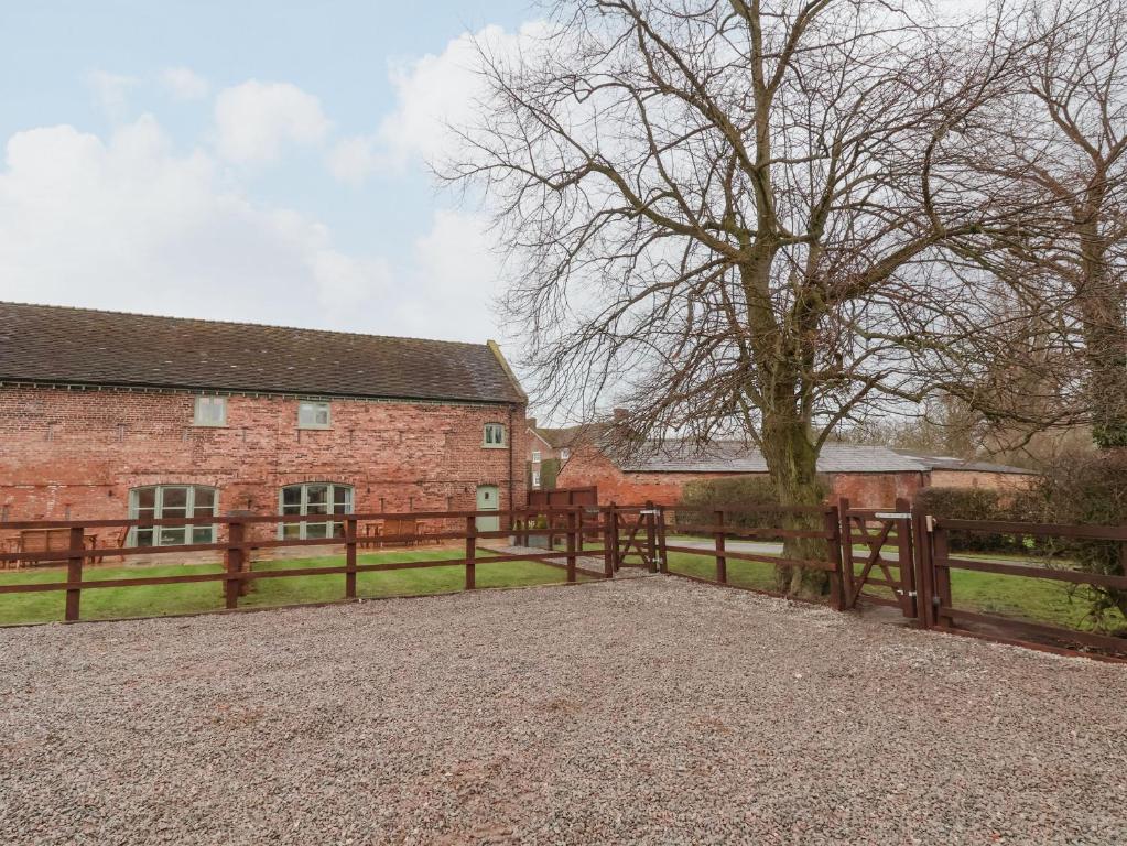 a wooden fence in front of a brick building at Oak Barn in Sandbach