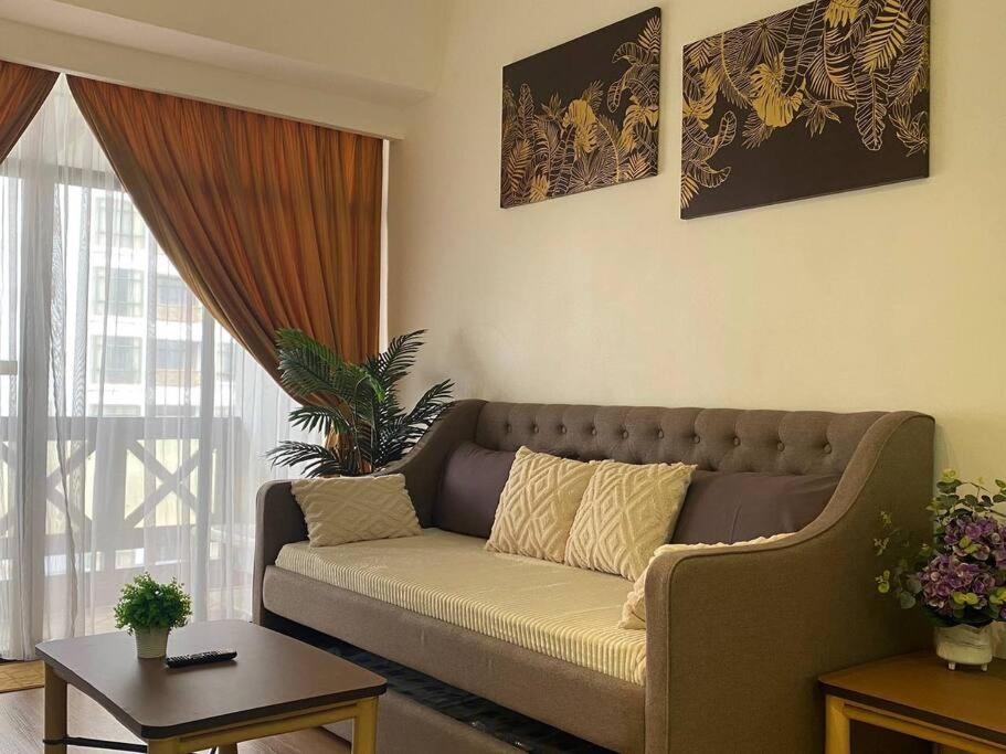 un soggiorno con divano e tavolo di Lovely 1-Bedroom Condo with Facilities a Malacca