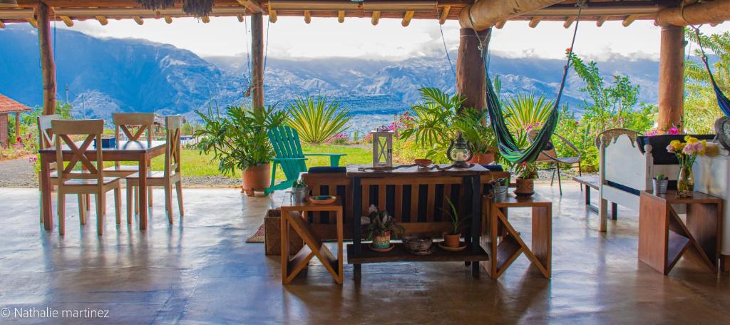 Habitación con mesas, sillas y vistas a las montañas. en Serrania del Viento, en Barichara