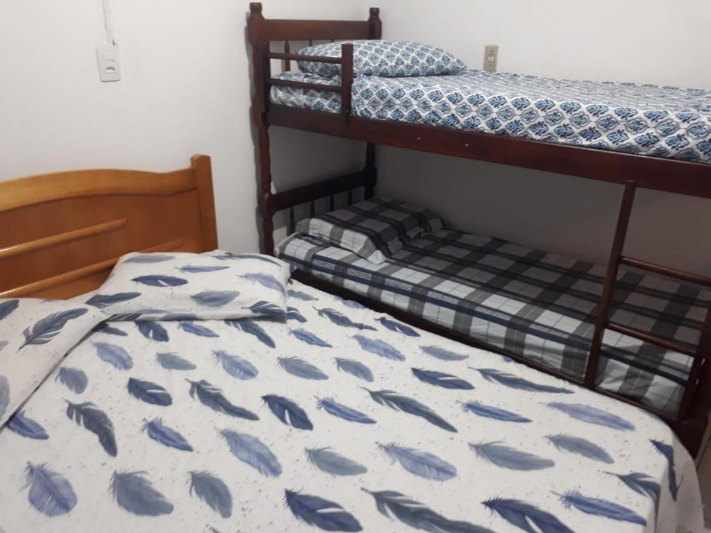 sypialnia z 2 łóżkami piętrowymi i narzutą z rybą w obiekcie Casas de Aluguel da Lulu w mieście Itapema