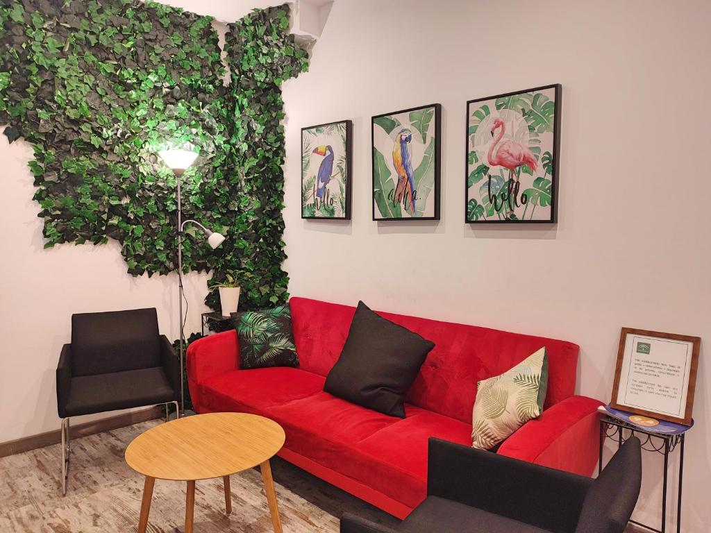 ein rotes Sofa im Wohnzimmer mit Pflanzen in der Unterkunft La Casa de Pedro Verdugo Apartamento Turístico in Córdoba