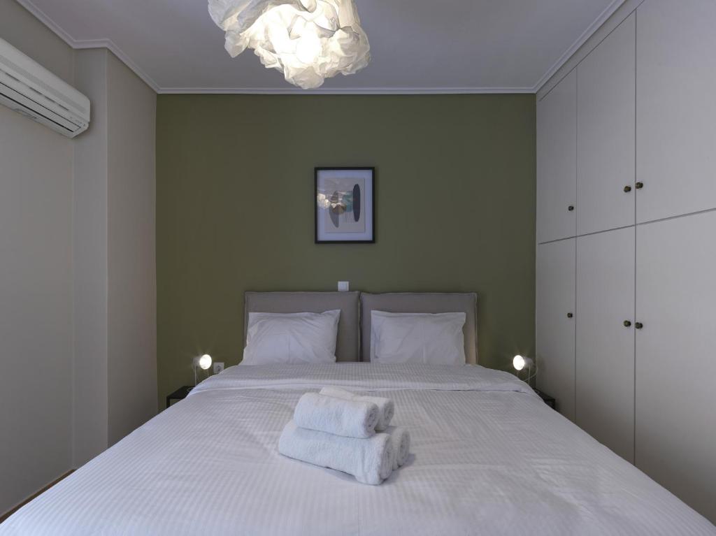 sypialnia z łóżkiem z białą pościelą i żyrandolem w obiekcie 2 bedroom apartment close to children's hospital w Atenach