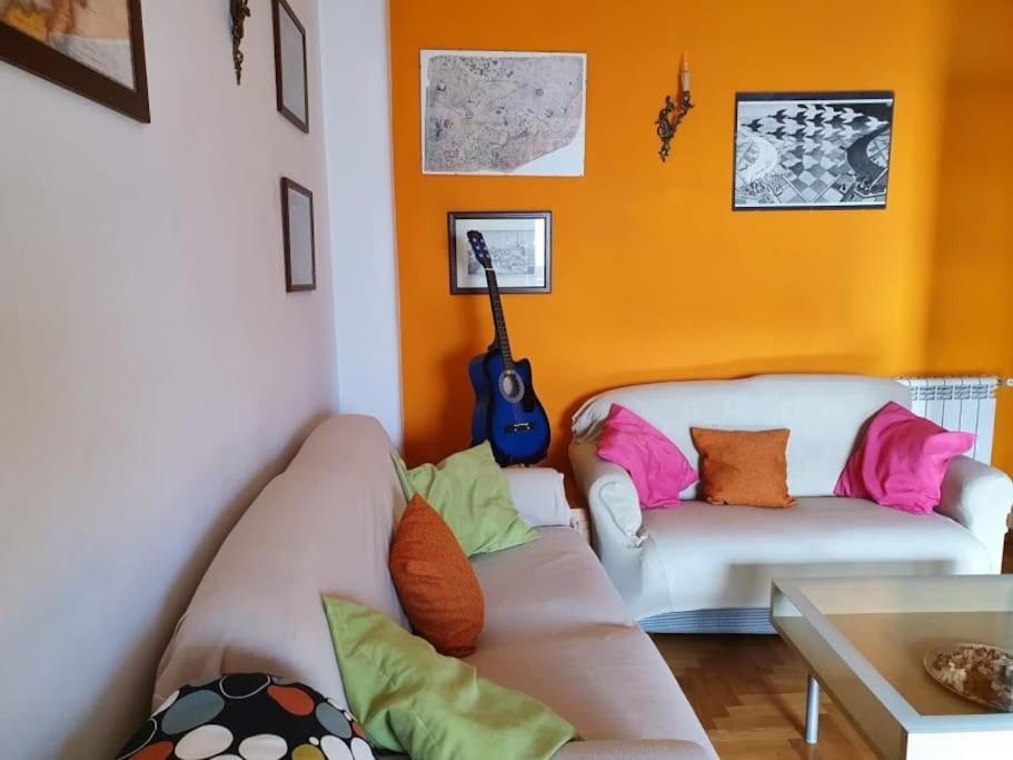 a living room with a couch and a guitar at WI-FI Clima Molfetta 26 in Rome