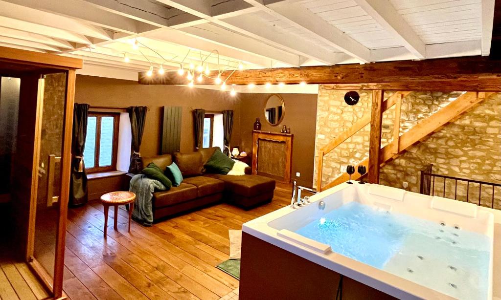 uma sala de estar com uma banheira no meio de um quarto em Le Secret de Mélin em Mélin