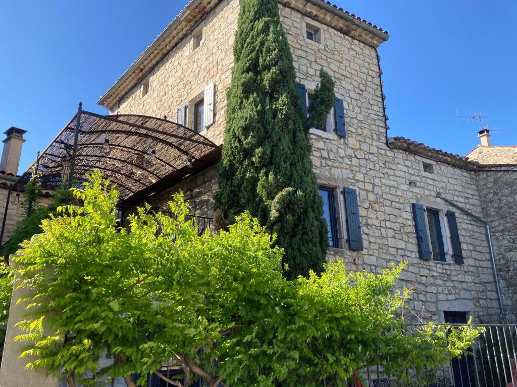 a building with a large tree on the side of it at La Stévenière in Chandolas
