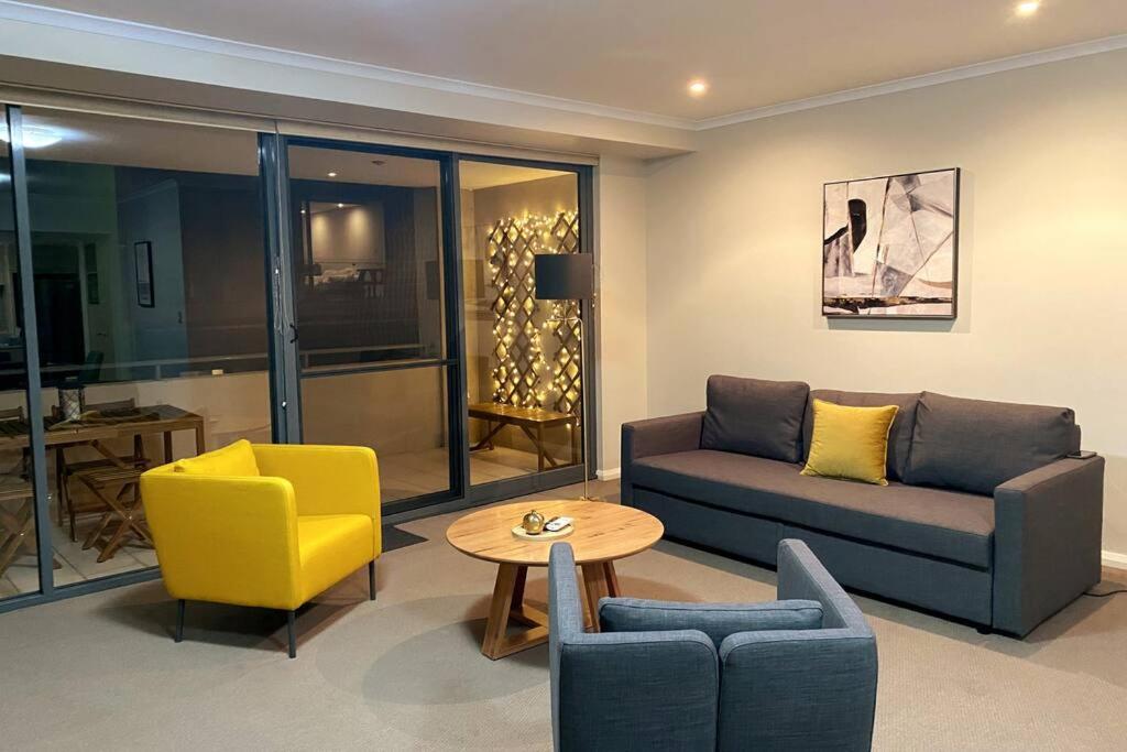 sala de estar con sofá, sillas y mesa en Bannister Apartment in vibrant central Fremantle, en Fremantle