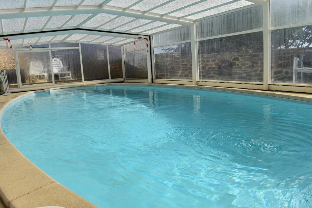 una gran piscina con techo en Au bon Accueil anciennement Le Jardin fleuri en Bonnac