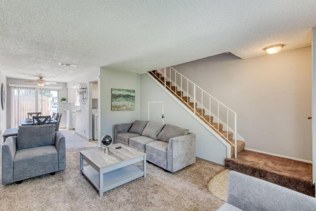 a living room with two couches and a staircase at Lovely 2 bedroom condo in quiet location in Fresno