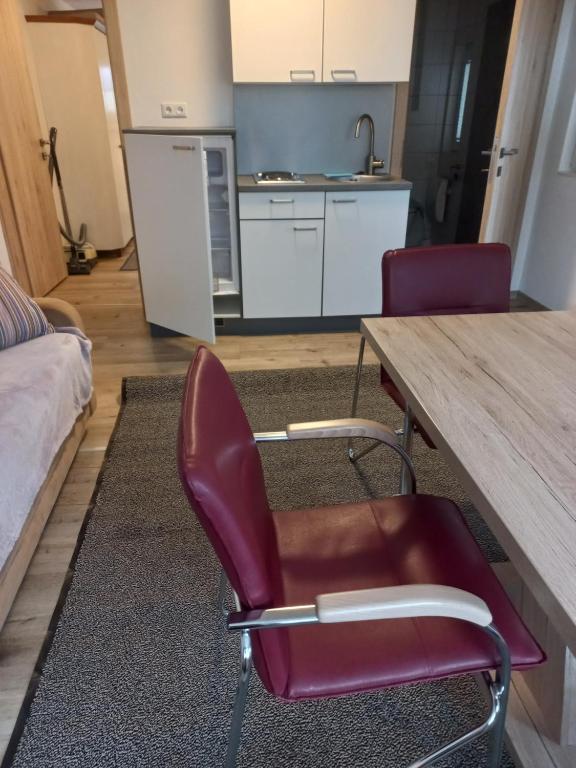 eine Küche mit einem Tisch und 2 Stühlen in einem Zimmer in der Unterkunft Ferienhaus Am-moore in Steindorf am Ossiacher See