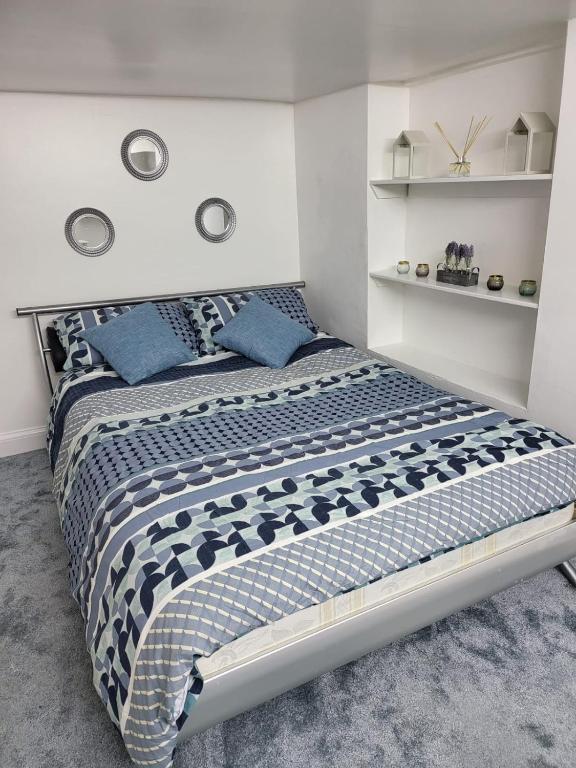 a bedroom with a large bed with blue pillows at Homey Flat in Tooting in London