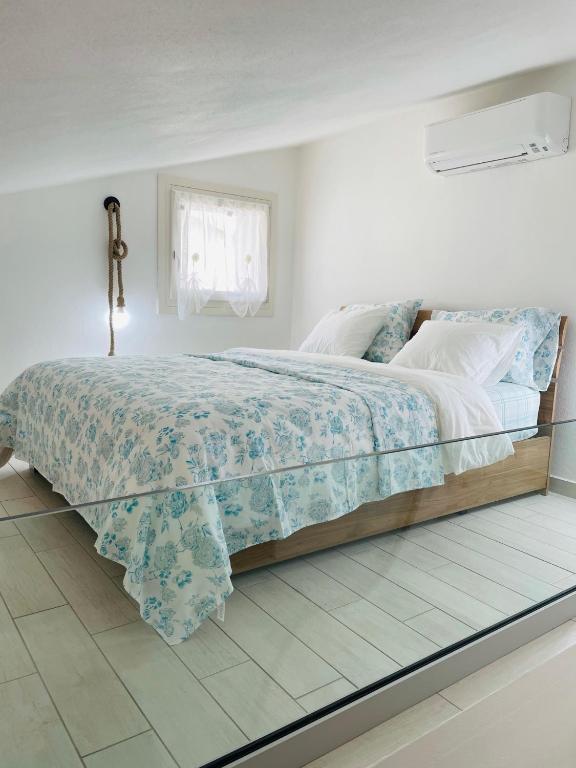 sypialnia z dużym łóżkiem z drewnianą ramą w obiekcie Zaffiro casa vacanze al mare w mieście Valledoria