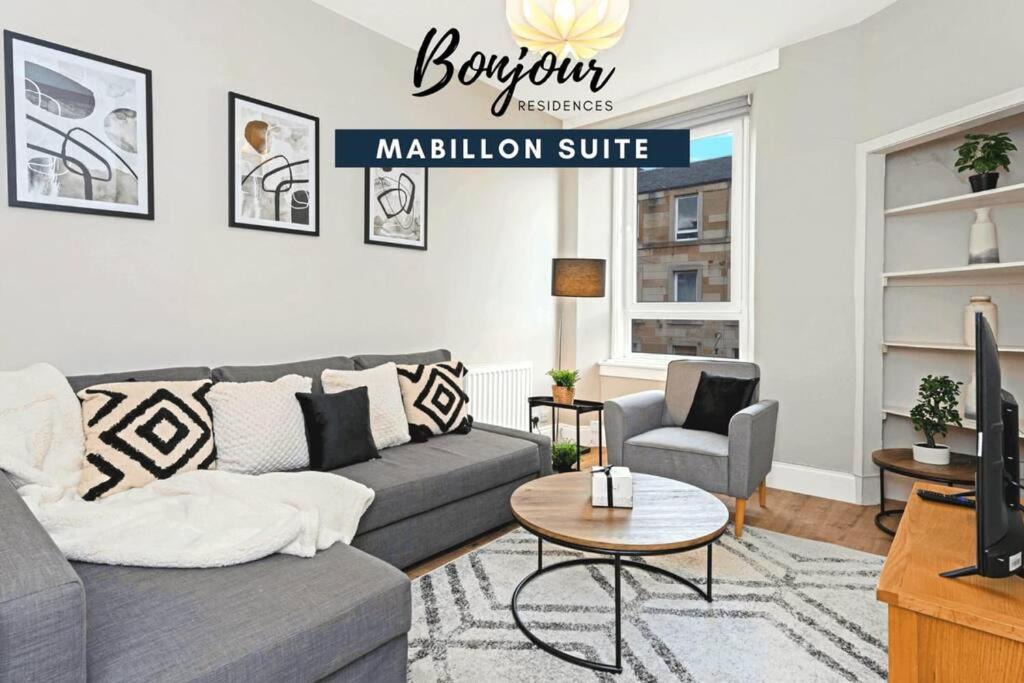 a living room with a gray couch and a television at Mabillon Suite - Gorgeous-Haymarket, City Centre-FREE Parking by Bonjour Residences Edinburgh in Edinburgh