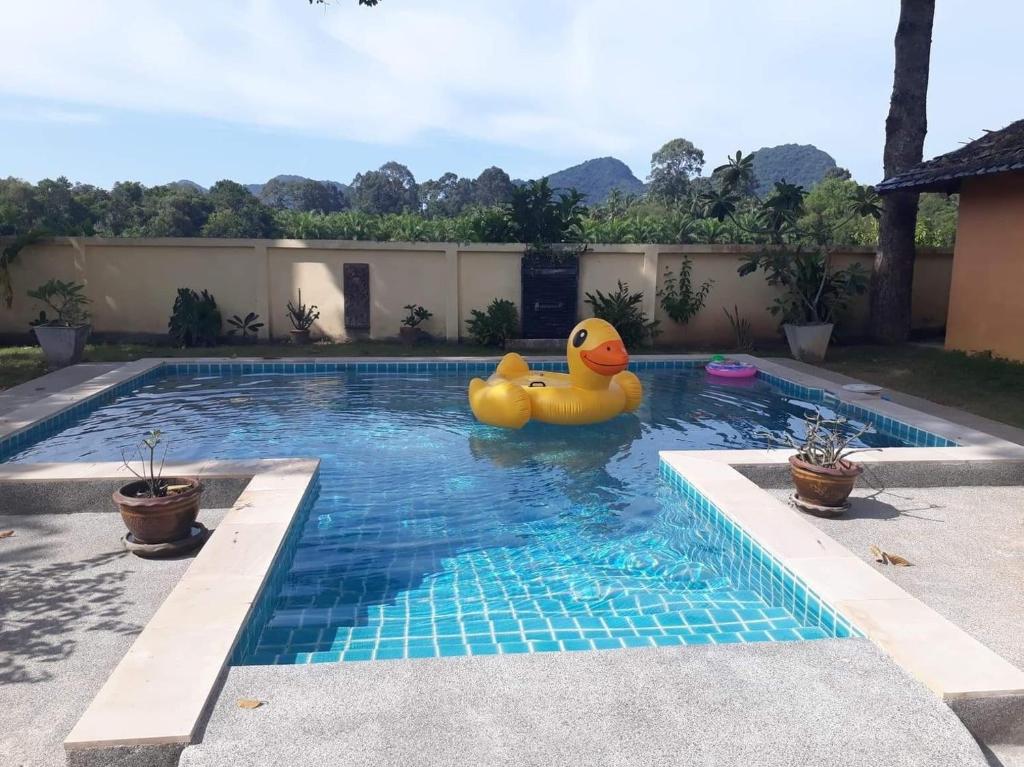 una piscina con un pato de goma en el agua en Khanom Garden Suite, en Khanom