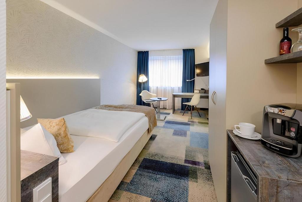 a hotel room with a bed and a tv at PLAZA INN Regensburg in Regensburg