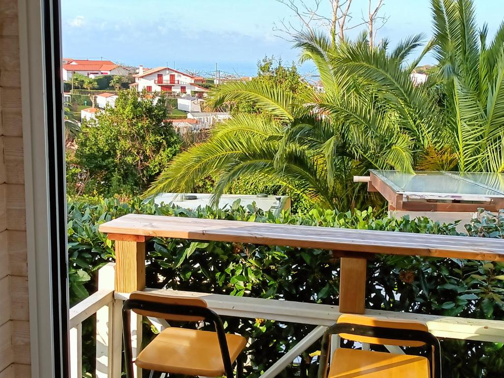d'un balcon avec une table, des chaises et des palmiers. dans l'établissement Mobil-home avec vue mer, à Saint-Jean-de-Luz