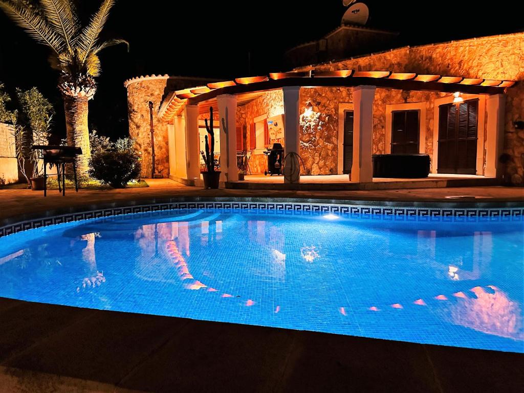 una piscina en un patio por la noche en Villa Sanchez in Strandnähe mit Pool, Jacuzzi, Klima, WiFi, Gas BBQ, en Santanyí