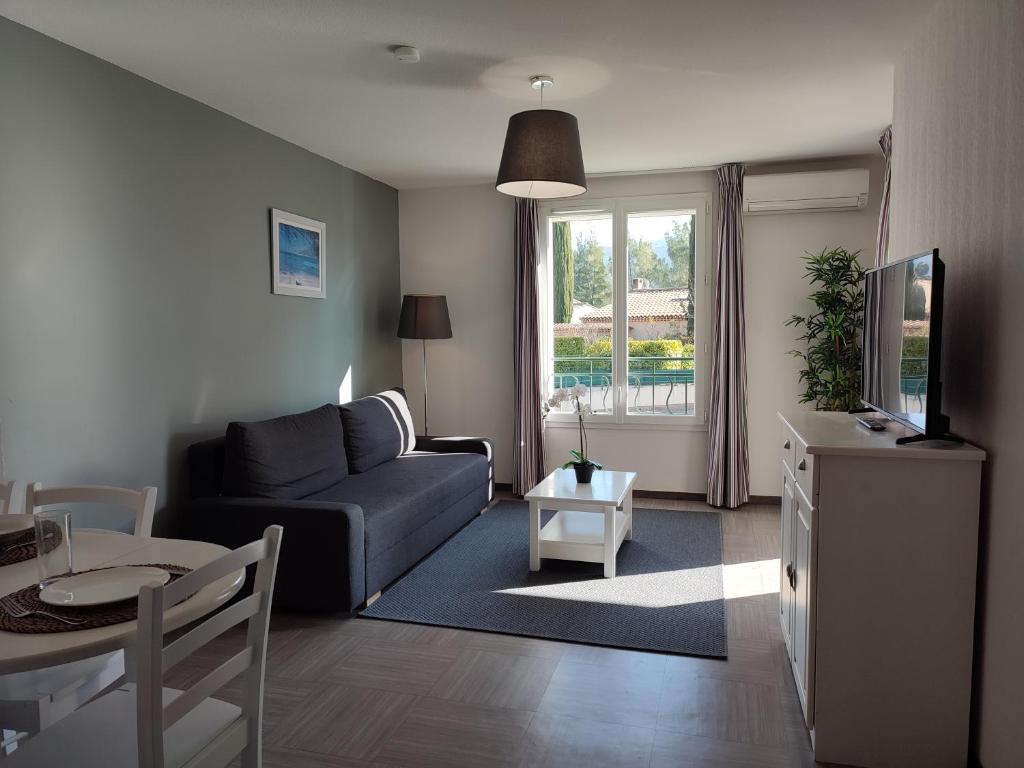 un salon avec un canapé et une table dans l'établissement Le Romarin - Climatisation piscine & parking privé, à Gréoux-les-Bains