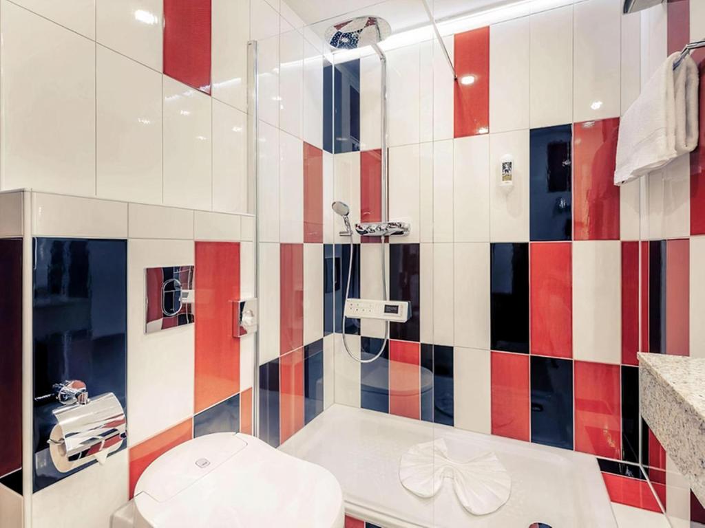 a bathroom with a shower and a toilet and a sink at PLAZA INN Regensburg in Regensburg