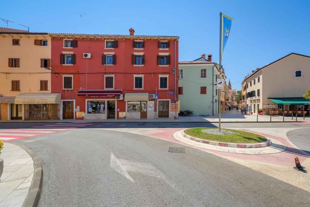 an empty street in a town with a red building at Apartments Dante in Umag
