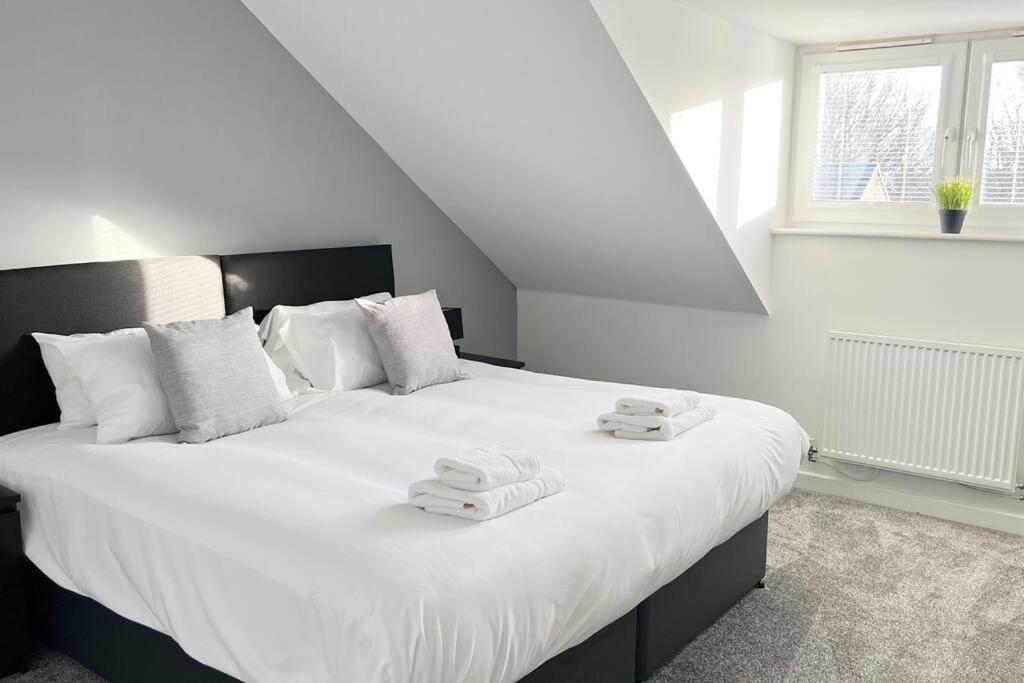 a bedroom with a large white bed with towels on it at Kingfisher House by Blue Skies Stays in Stockton-on-Tees