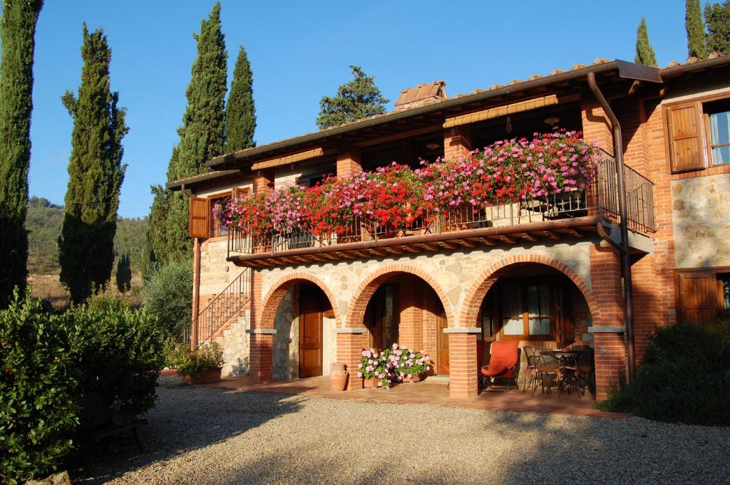 a building with a balcony with flowers on it at Poggio Ugo in Bucine