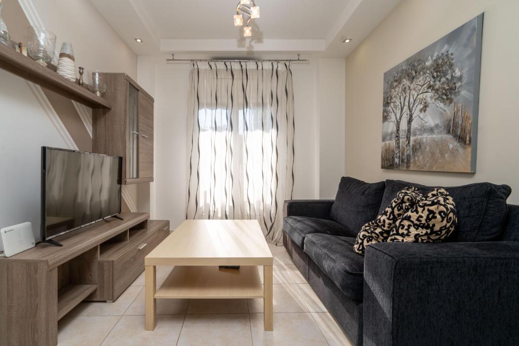 een woonkamer met een bank en een tv bij Kountouriotou New Quiet and Central apartment in Athene