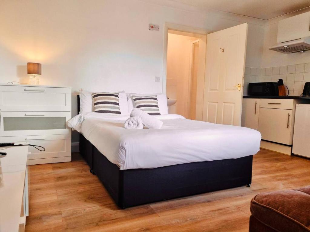 a bedroom with a large bed with white sheets at Midewell Court by Kasar Stays in Otford