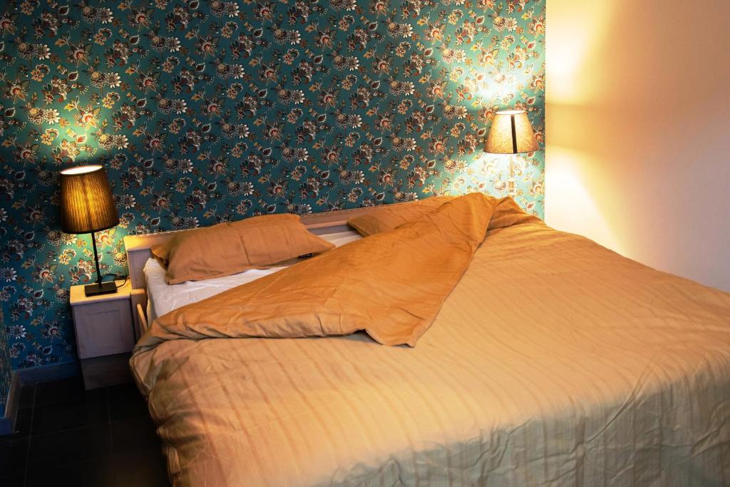 a bedroom with a large bed with green wallpaper at Vakantiewoning De Luysmolen in Bocholt