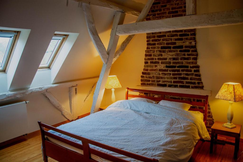 a bedroom with a bed and a brick wall at Vakantiewoning De Luysmolen in Bocholt