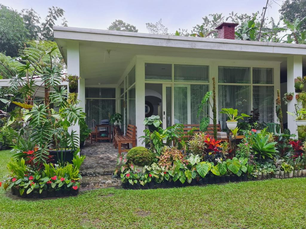una casa con flores y plantas delante de ella en The Forest Villa, en Bogor