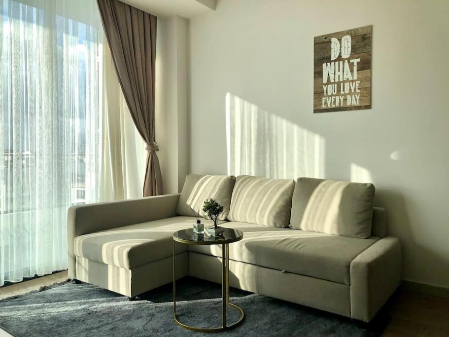ein Wohnzimmer mit einem Sofa und einem Tisch in der Unterkunft Secured Lux 1 + 1 apartment - Gym, Sauna & Parking ( EMP 193 ) in Esenyurt