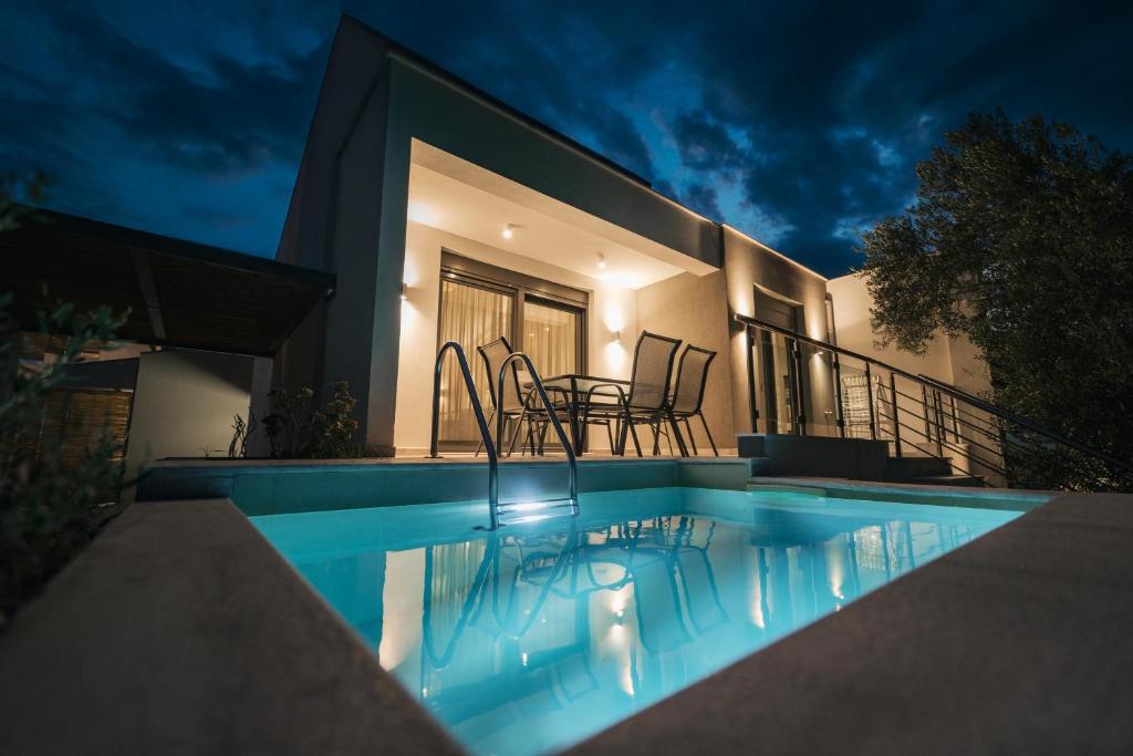 Villa con piscina por la noche en Octo Villas Complex en Iraklitsa