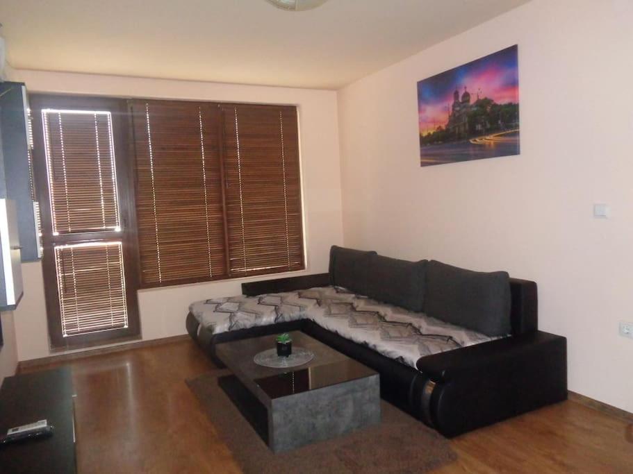 un soggiorno con divano nero e tavolino da caffè di Home Relax Varna a Varna