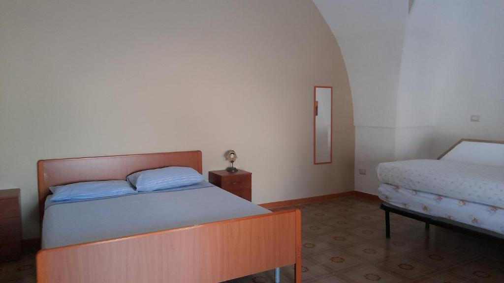 a bedroom with two beds and a mirror at CASA DELLE PEONIE in Ruffano