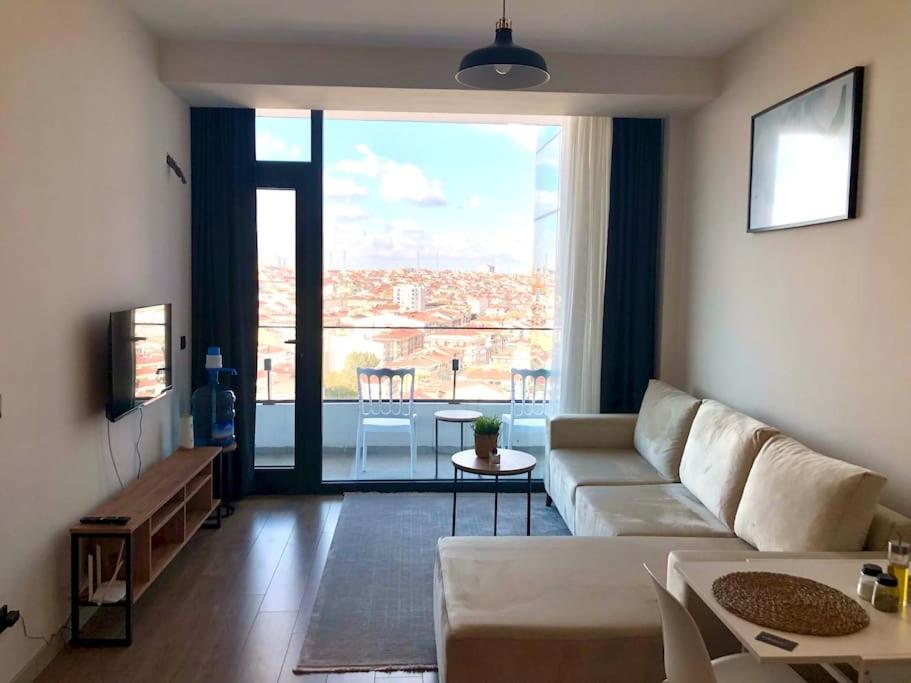 ein Wohnzimmer mit einem Sofa und einem großen Fenster in der Unterkunft Luxury Flat, Amazing city view. Gym & Parking ( EMP 271 ) in Esenyurt