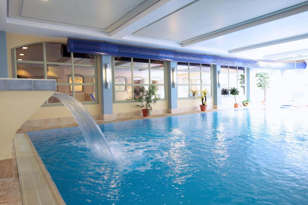 a swimming pool with a water fountain in a building at Ringhotel Fährhaus in Bad Bevensen