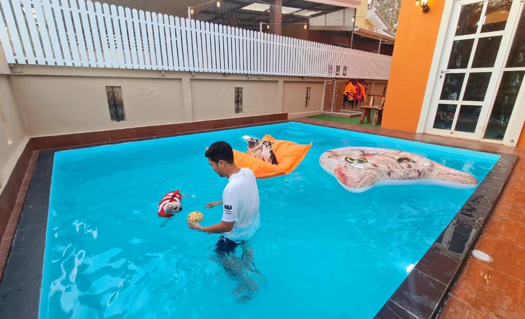 un hombre parado en el agua en una piscina en บ้านสามหมา pool villa เขาใหญ่, en Ban Pang Asok