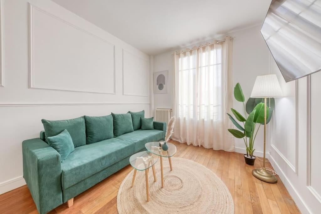 - un salon avec un canapé vert et une table dans l'établissement Oh Parisien - 10 min Paris Montparnasse, à Vanves