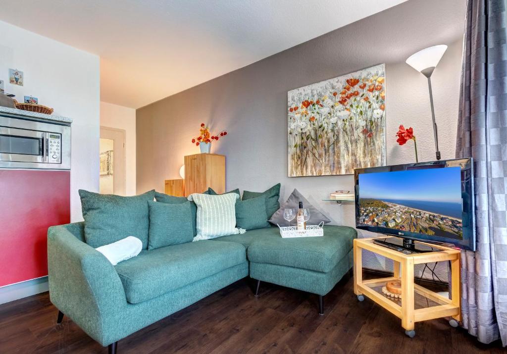班辛海的住宿－Villa Margot - FeWo 02，客厅配有蓝色的沙发和电视